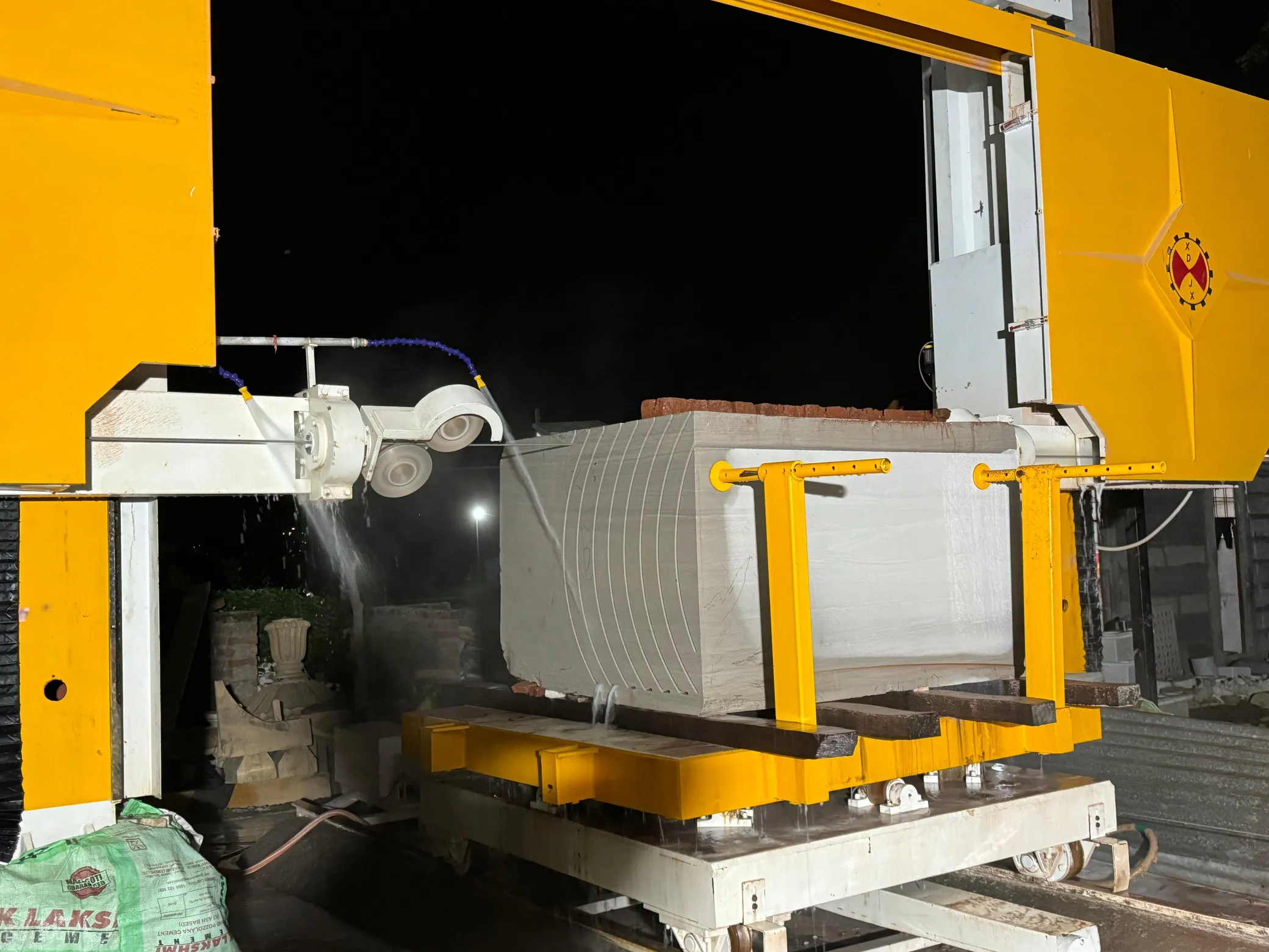 CNC wire saw cutting a block at night