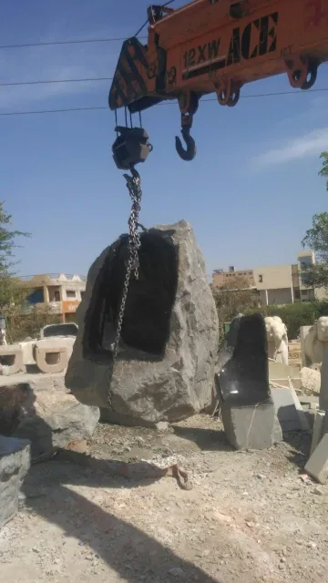 Raw stone block being lifted by crane