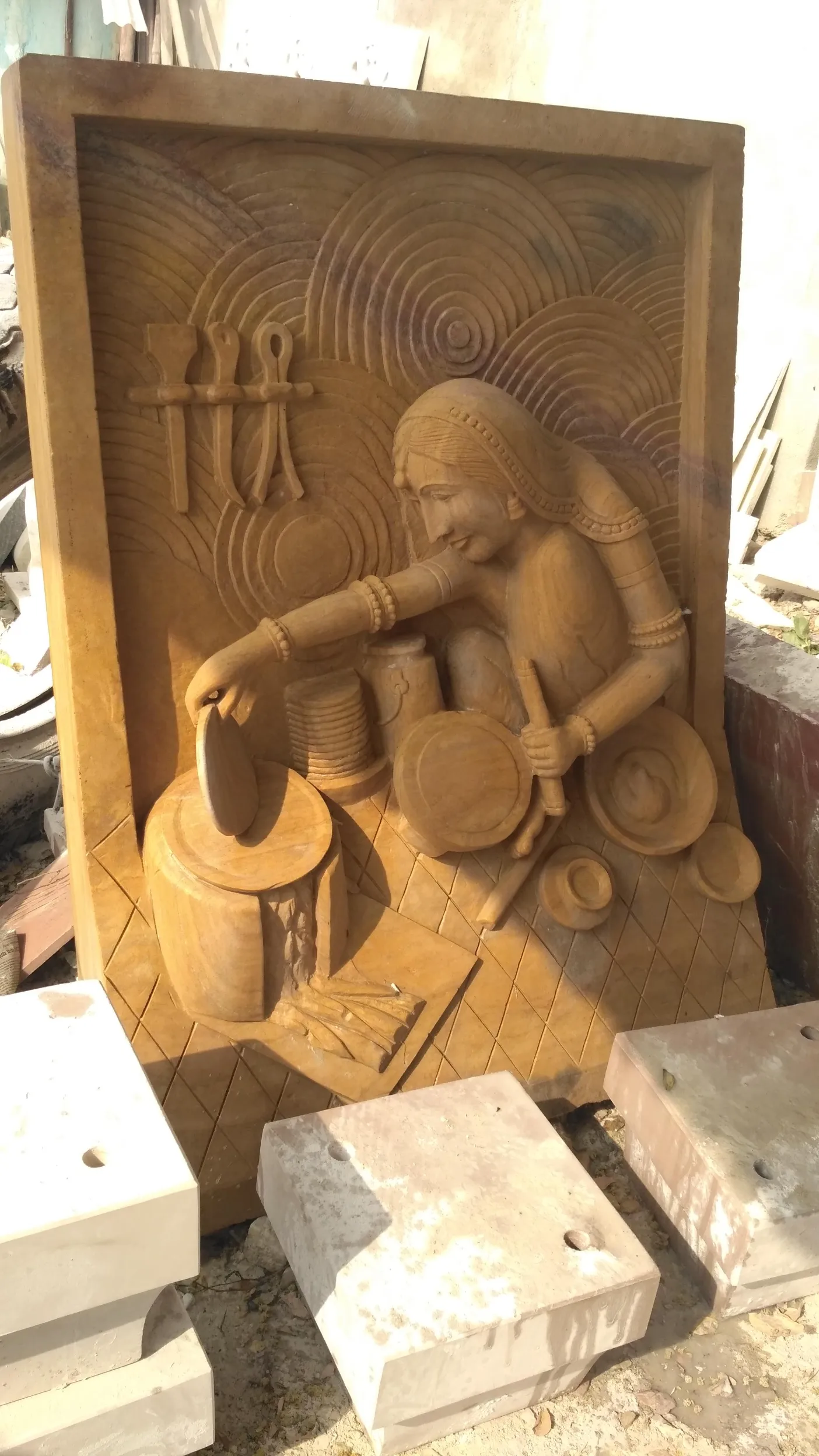 Sandstone relief carving of a village woman at work