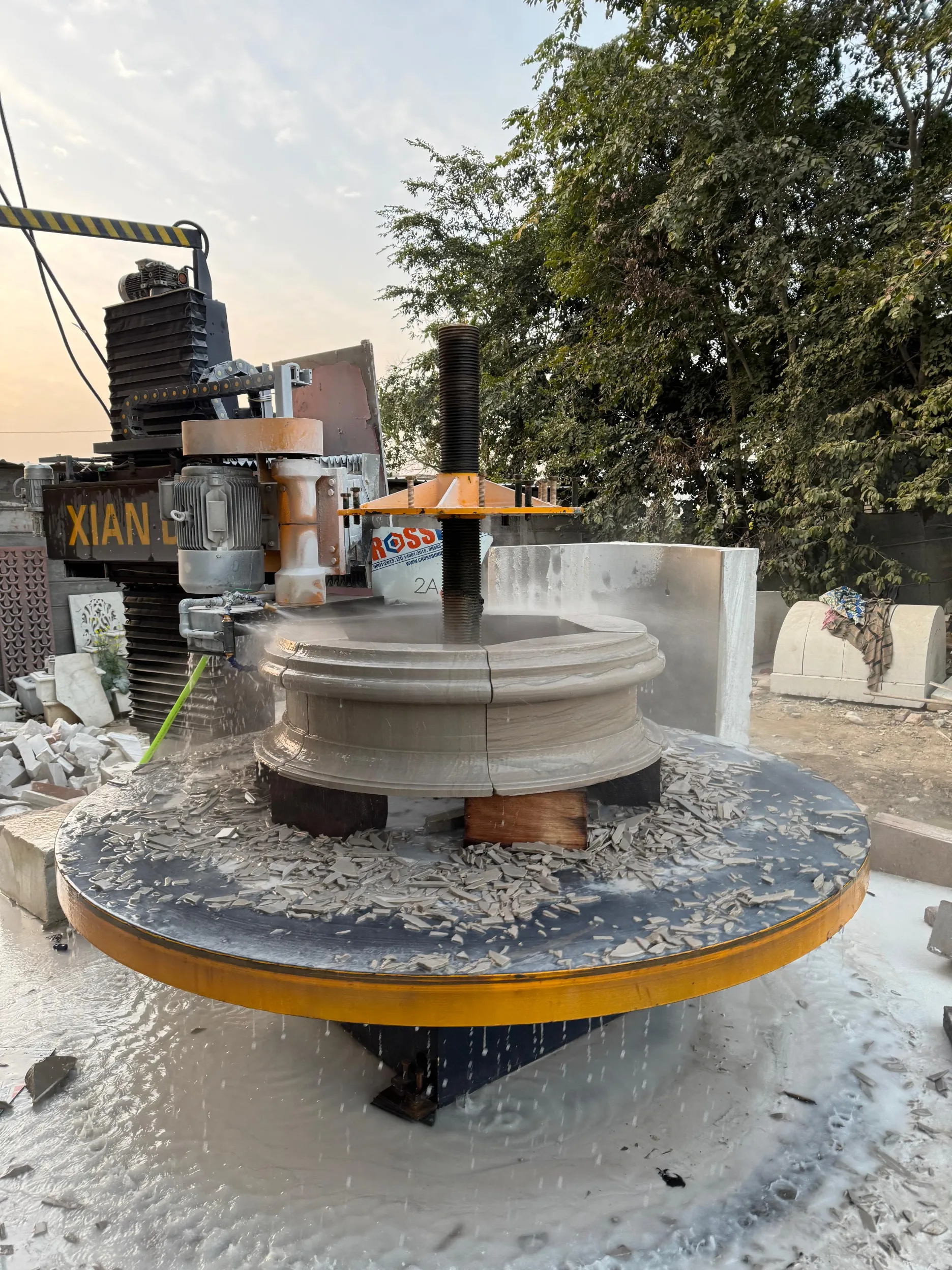 Column turning machine shaping a profiled stone column base