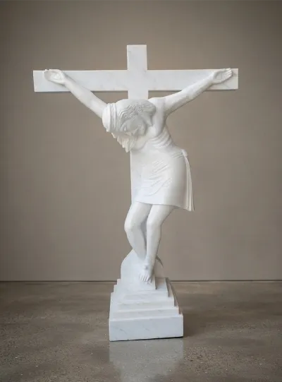White marble crucifix sculpture of Jesus on a stepped base