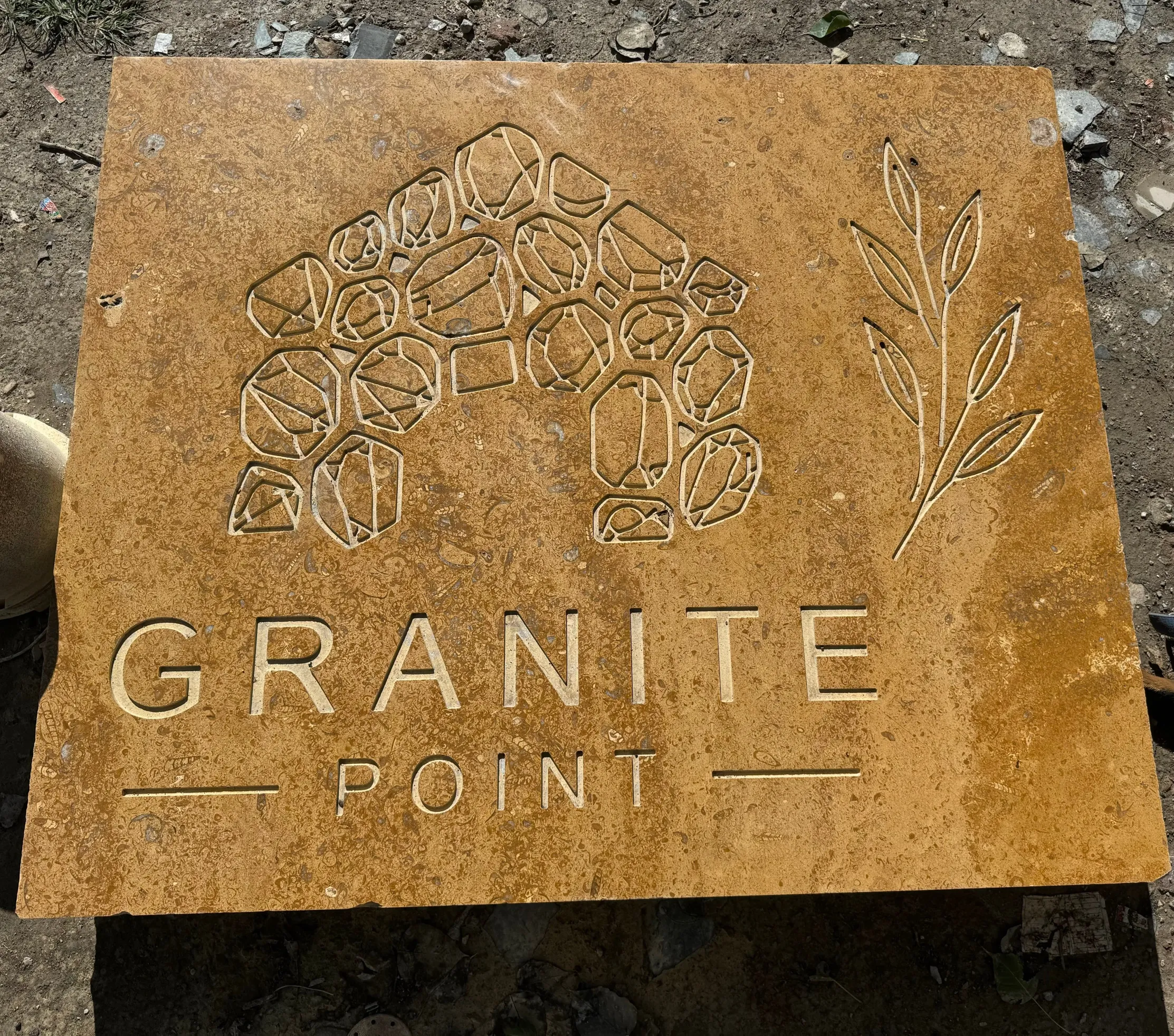 Engraved stone with lettering and line art