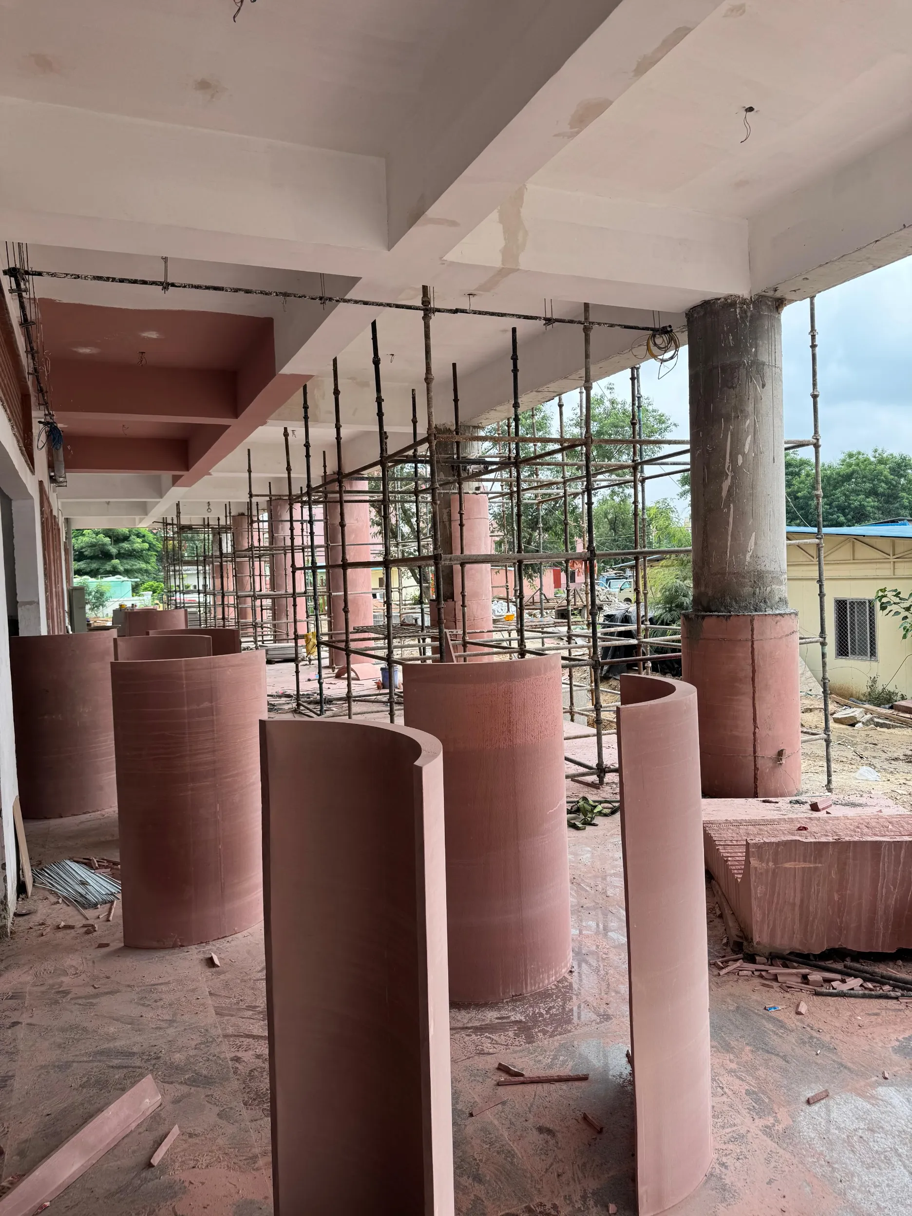 Cut stone column drums and a pillar being erected