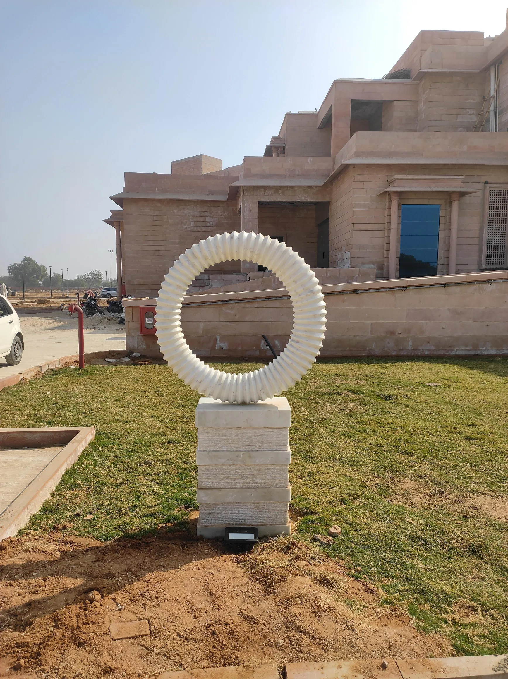 Marble ring sculpture on a landscaped lawn