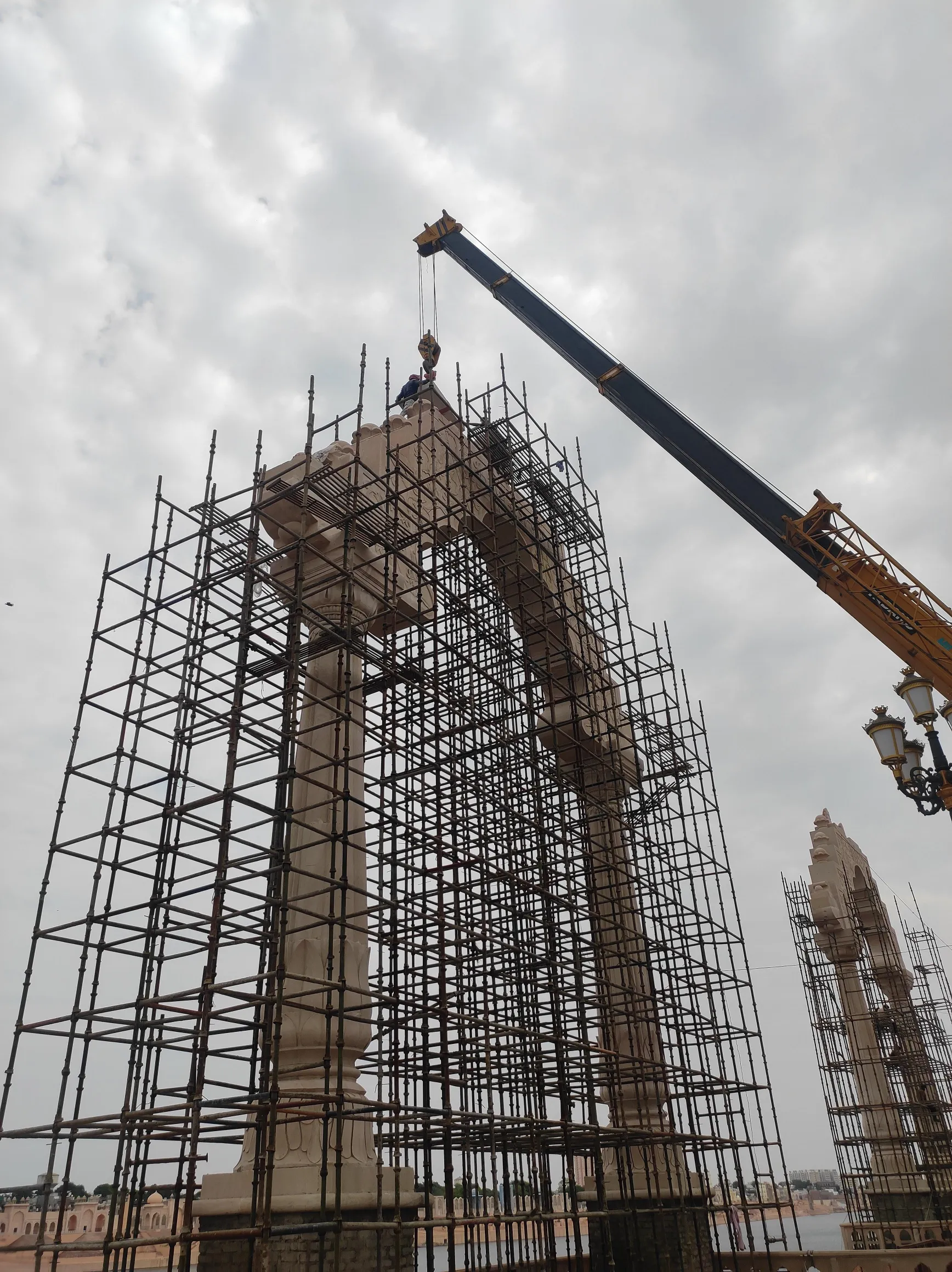 Crane lifting carved stone onto an arch column – Grand Arch, Kota