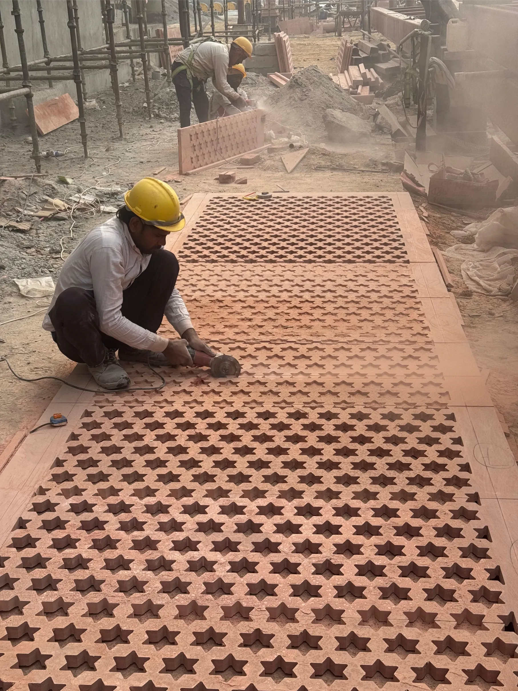 Craftsman finishing a carved sandstone jali panel – Jaipur Junction Redevelopment, Jaipur