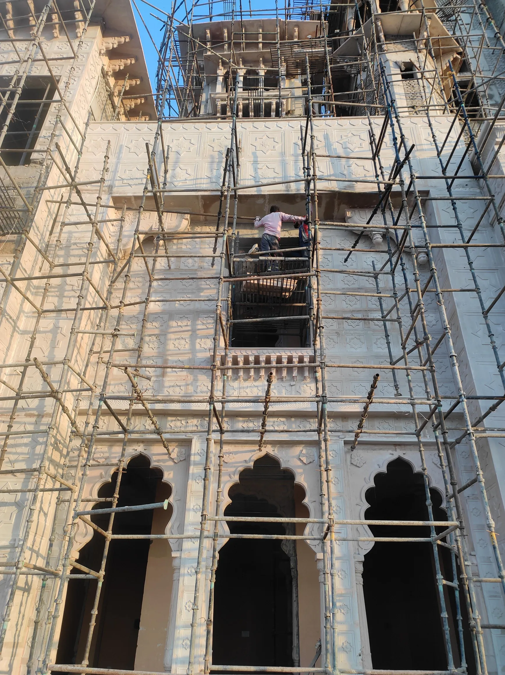 Carved arches and stone frames on scaffolding – Mukut Mahal, Kota