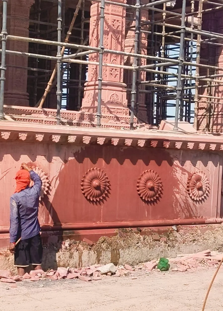 Artisan finishing carved rosettes on the red sandstone plinth – Sant Ravidas Temple, Sagar