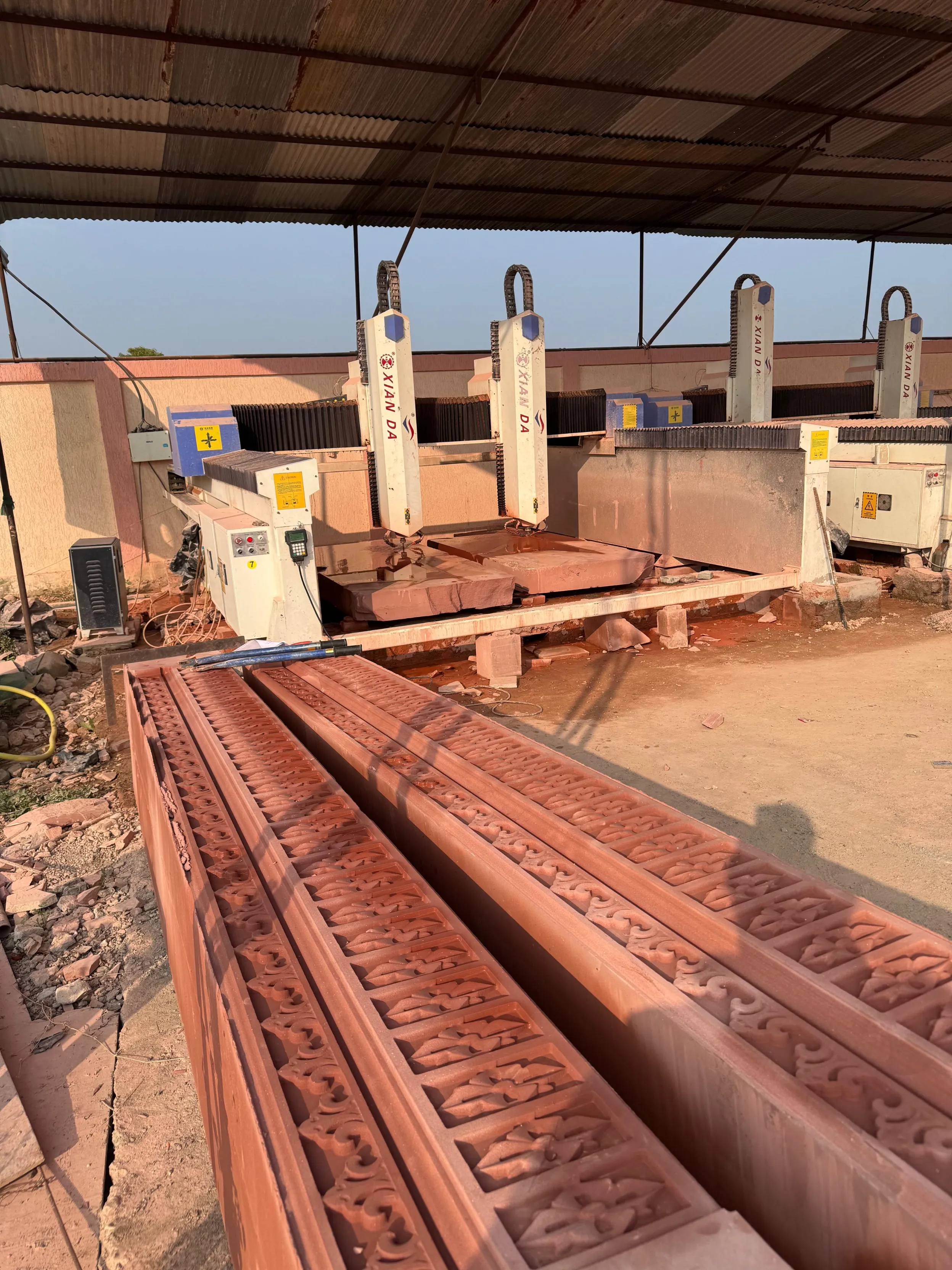 CNC machines with freshly carved red sandstone mouldings at the Umang Arts workshop