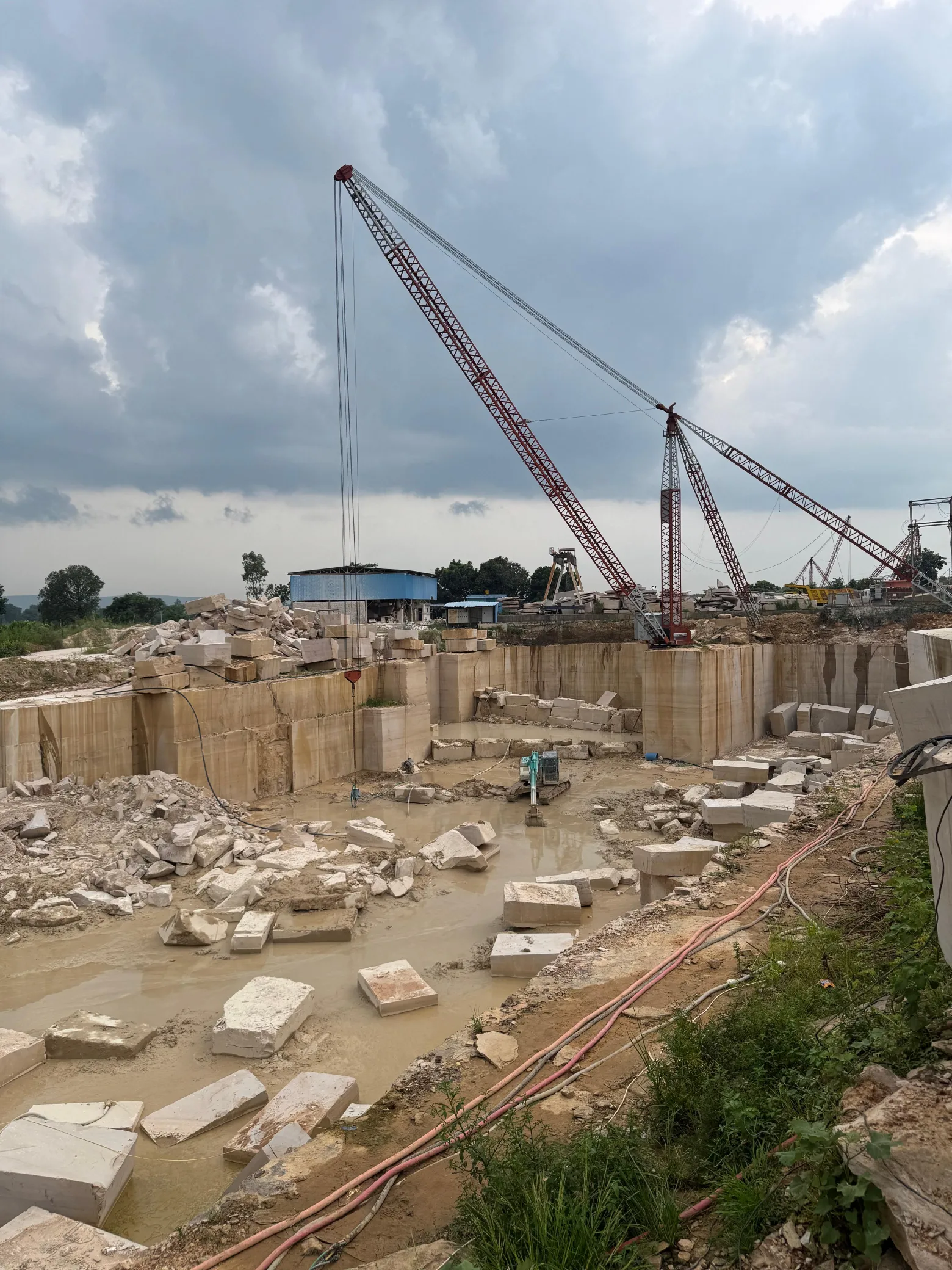 Raw natural stone block being lifted at the stone yard