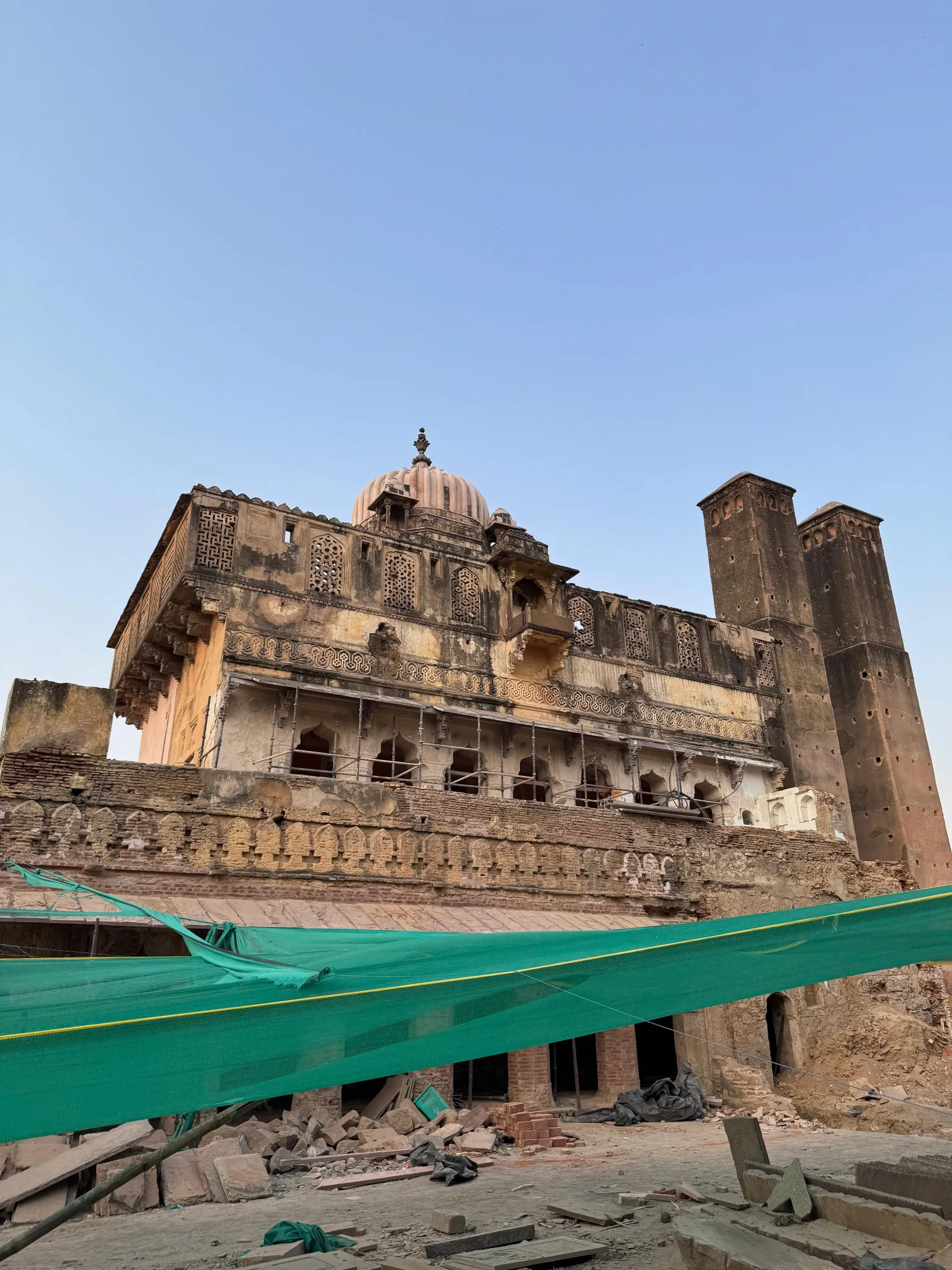Historic stone palace protected with netting during conservation works