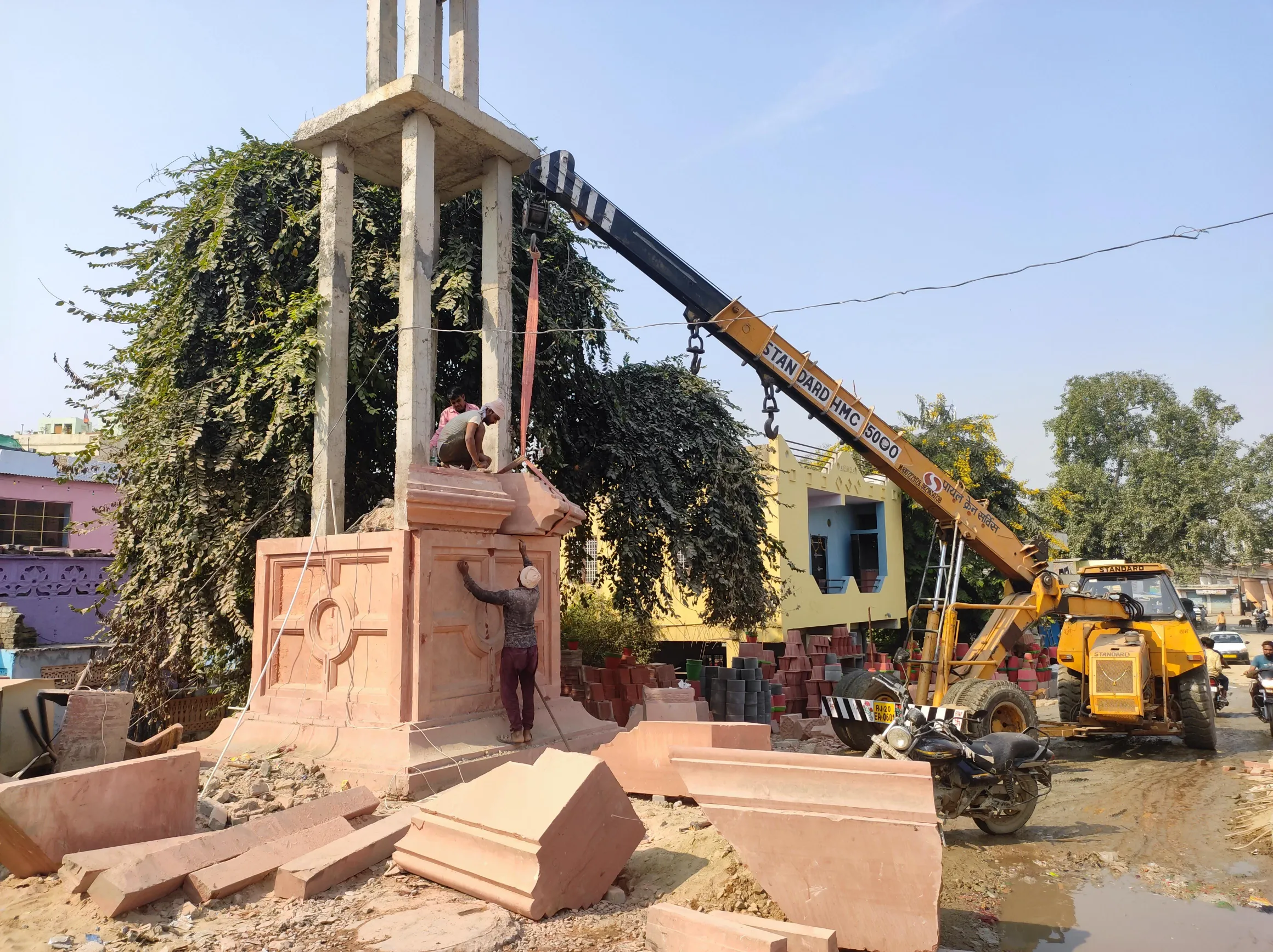 Crane placing a carved sandstone pedestal